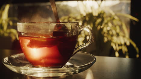 Sugar-with-a-slice-of-lemon-is-hammered-into-a-cup-of-tea.-The-light-from-the-window-beautifully-illuminates-the-cup-and-spoon