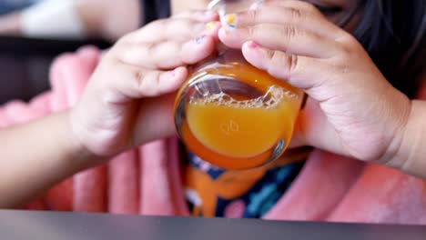 Child-drinking-orange-juice-closeup,