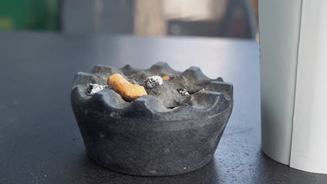 Close-up-burning-cigarette-in-ashtray-,
