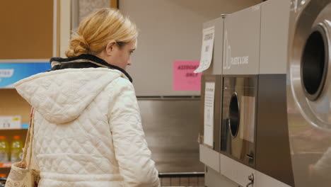 Lockport,-NY,-USA,-October-2021:-A-woman-puts-drinks-cans-into-the-machine.-She-scans-the-barcode,-for-the-delivered-container-she-receives-a-reward-check.