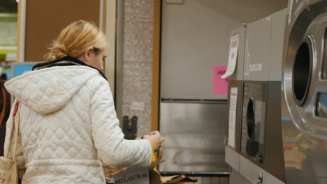 Lockport,-NY,-USA,-October-2021:-A-woman-puts-drinks-cans-into-the-machine.-She-scans-the-barcode,-for-the-delivered-container-she-receives-a-reward-check.