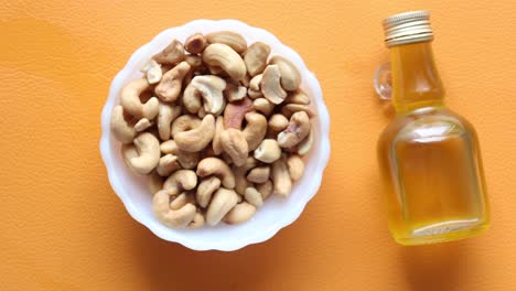 Cashew-nuts-and-oil-jar-on-table-,