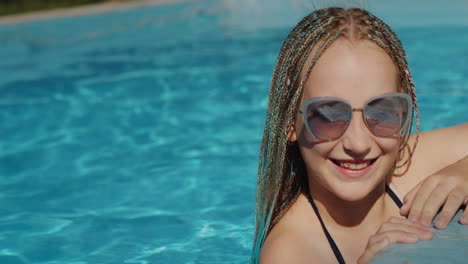 Portrait-of-a-child-in-the-pool,-looking-into-the-camera,-smiling