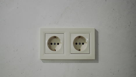 Double-European-type-electrical-outlet-on-the-wall-in-the-house.-The-camera-moves-slowly-towards-the-wall-with-a-power-outlet