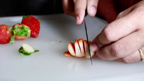 Women-hand-cutting-red-strawberries