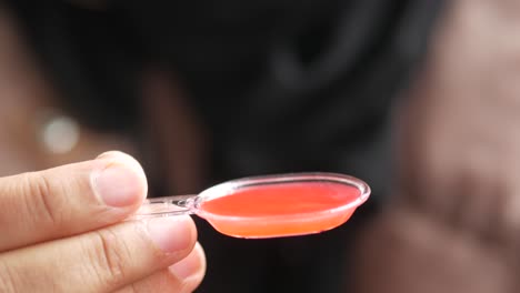 Pouring-liquid-medicine-on-spoon