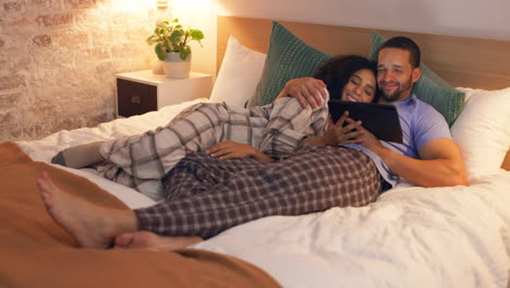 Couple,-happy-and-relax-in-bedroom-with-tablet