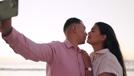 Selfie,-kiss-and-couple-at-the-beach-for-travel