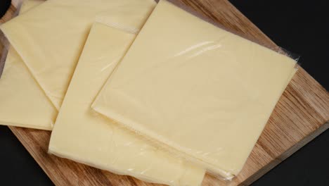Transparente-Packung-Mit-Käsescheiben-Auf-Gelb