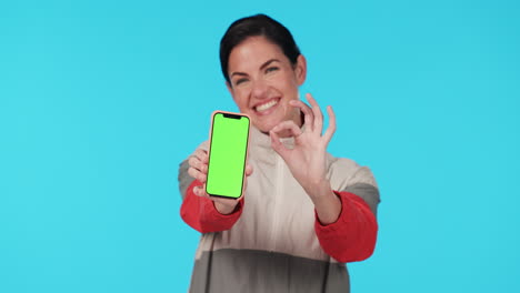 Woman,-point-and-phone-green-screen-in-studio