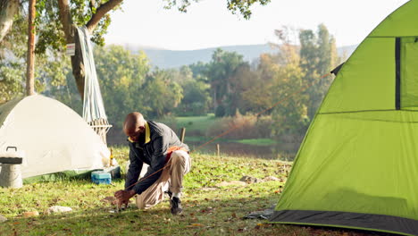 Camping,-tent-and-black-man-setup-in-woods