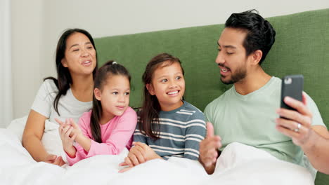 Mother,-father-and-children-on-video-call-in-bed