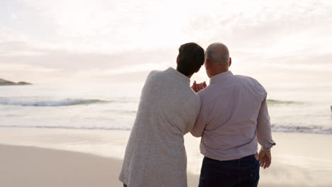 Senior-couple,-beach-and-talking-outdoor-at-sunset