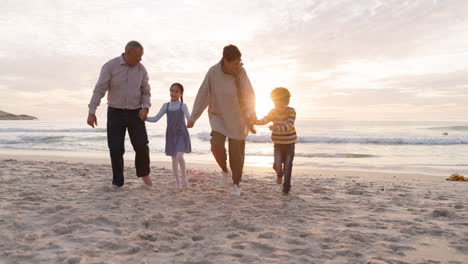 Family,-beach-and-holding-hands-with-parents
