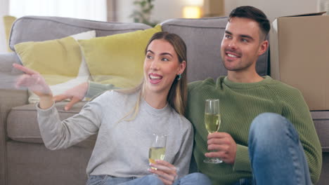 Couple,-champagne-and-sitting-on-floor-in-new