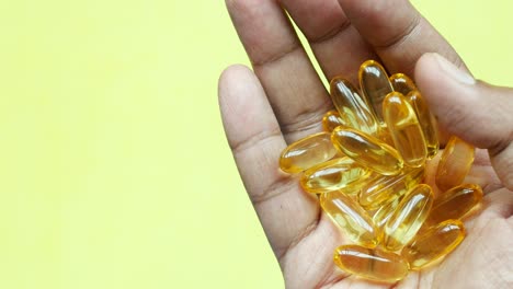 Fish-oil-supplement-on-hand-top-view