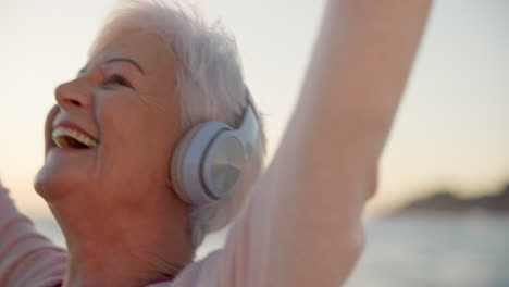 Dancing,-headphones-and-senior-woman-at-the-beach