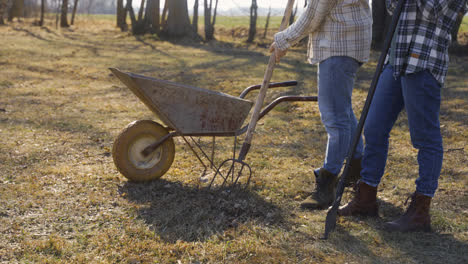 Caucasian-couple-removing-weeds-with-a-rake-in-the-countryside