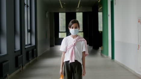 Schulmädchen-Mit-Gesichtsmaske-Im-Schulkorridor.
