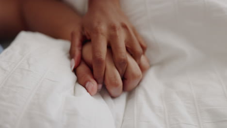 Love,-intimacy-and-couple-holding-hands-in-bed