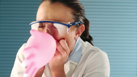 Pretty-medical-student-blowing-balloon-with-glove