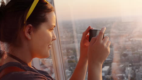 Tourist-taking-photograph-of-sunset-in-london-skyline--view-from-The-Shard