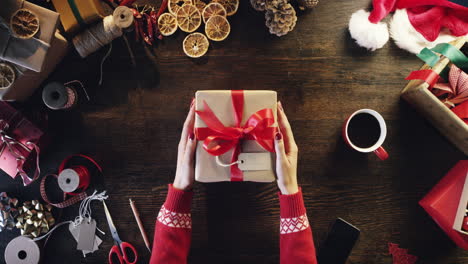 Hände-Von-Oben,-Die-Weihnachtsgeschenke-Am-Holzschreibtisch-Halten-–-Roter-Epischer-Drache