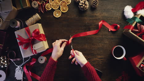 Top-view-hands-cutting-ribbon-christmas-presents-craft-table-from-above---Red-Epic-Dragon