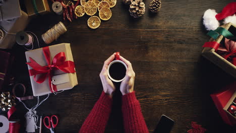 Top-view-hands-drinking-coffee-christmas-presents-table-from-above---Red-Epic-Dragon