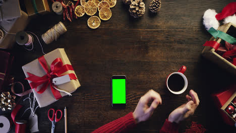 Top-view-christmas-hands-drinking-coffee-using-smartphone-shopping-online--from-above---Red-Epic-Dragon