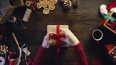 Hände-Von-Oben,-Die-Weihnachtsgeschenke-Am-Holzschreibtisch-Einpacken---Roter-Epischer-Drache