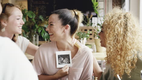 Schwangere-Frau-Zeigt-Freunden,-Die-Feiern,-Ein-Ultraschallbild-Des-Babys