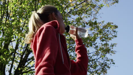 Runner-woman-drinking-water-bottle-sun-flare-solar-energy