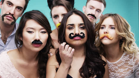 Multirassische-Gruppe-Von-Menschen,-Die-Falschen-Schnurrbart-Für-Die-Fotokabine-Einer-Movember-Zeitlupenparty-Tragen