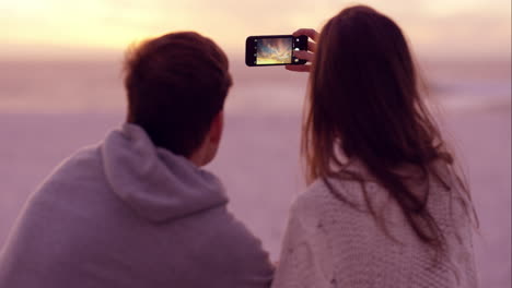 Happy-romantic-couple-taking-photograph-of-sunset-using-mobile-phone-camera-shot-on-RED-DRAGON