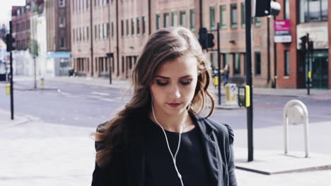 Attractive-business-woman-commuter-using-smartphone-walking-in-city-of-london