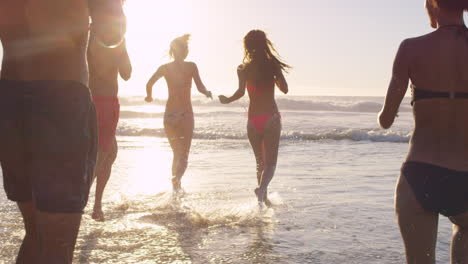 Diverse-Group-of-friends-swimming-in-the-sea-at-sunset