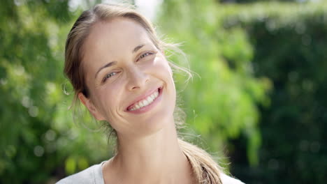 Portait-of-beautiful-woman-smiling-outdoors-slow-motion