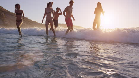 Diverse-Group-of-friends-swimming-in-the-sea-at-sunset