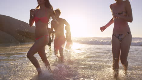Eine-Vielfältige-Gruppe-Von-Freunden-Schwimmt-Bei-Sonnenuntergang-Im-Meer