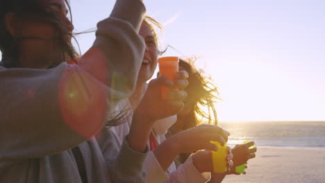 Girl-friends-blowing-bubbles-on-beach-at-sunset-slow-motion