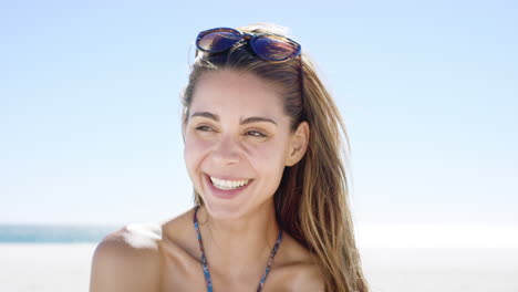 Close-up-portrait-of-beautiful-young-woman-smiling-on-tropical-beach-slow-motion
