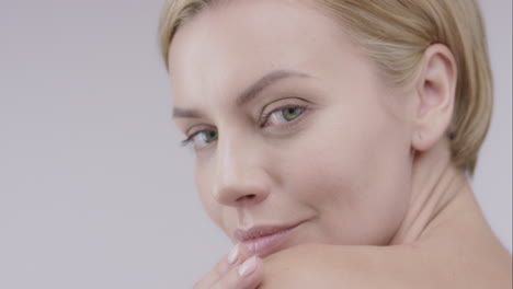Beautiful-healthy-woman-touching-smooth-skin-on-face-in-slow-motion-for-beauty-skincare-concept-on-a-grey-background-Red-Epic-Dragon