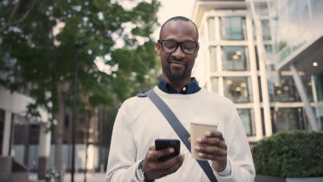 Afroamerikanischer-Geschäftsmann,-Der-Mit-Dem-Smartphone-Durch-Die-Stadt-Läuft