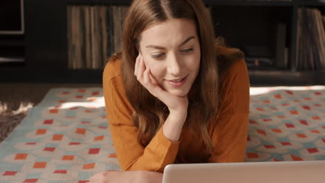 Beautiful-happy-woman-talking-to-her-fiance-using-internet-app-on-laptop-at-home-smiling