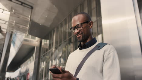 Afroamerikanischer-Geschäftsmann,-Der-Mit-Dem-Smartphone-Durch-Die-Stadt-Läuft