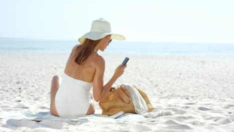 Woman-using-credit-card-shopping-online-with-mobile-phone-at-the-beach-on-vacation