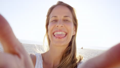 Hermosa-Mujer-Tomando-Selfie-Usando-El-Teléfono-En-La-Playa-Al-Atardecer-Sonriendo-Y-Girando-De-Vacaciones