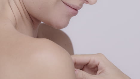 Beautiful-healthy-woman-stroking-neck-touching-skin-in-slow-motion-for-beauty-skincare-concept-on-a-grey-background-Red-Epic-Dragon