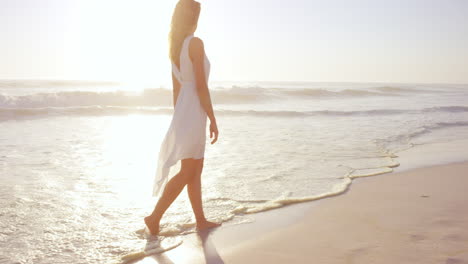 beautiful-woman-wearing-white-dress-walking-on-beach-at-sunset-in-slow-motion-RED-DRAGON